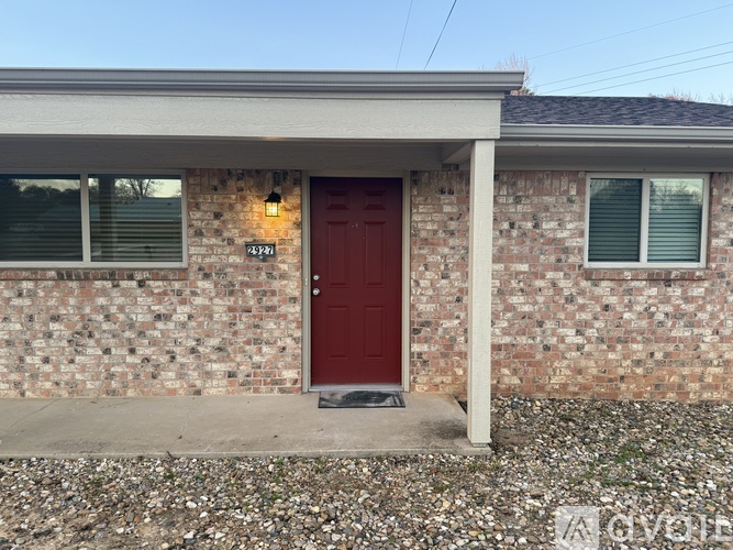 A house with a red door and a stone wall.
