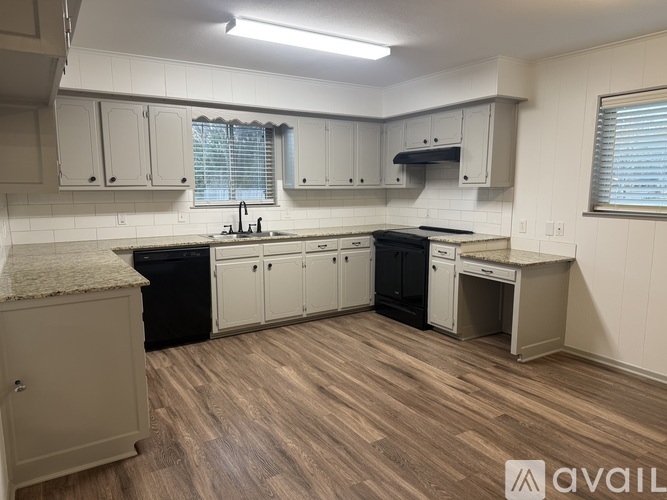 A kitchen with wooden floors and white walls.
