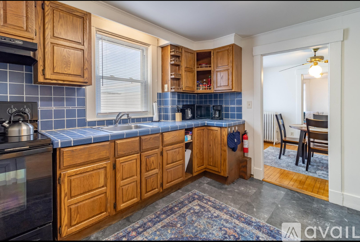 A kitchen with wooden cabinets and a blue tile backsplash.