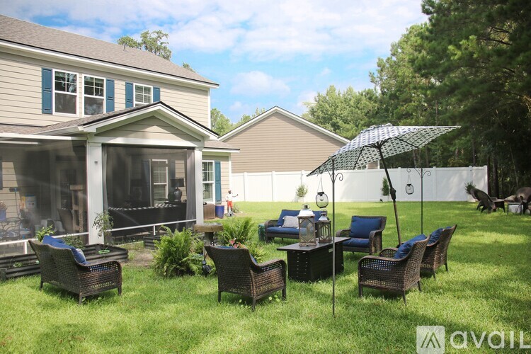 A patio with a table and chairs and an umbrella.