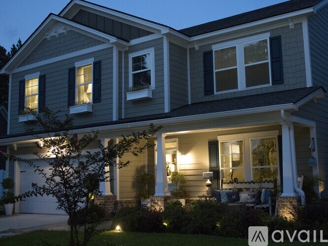 A house with a front porch and a tree in front of it.