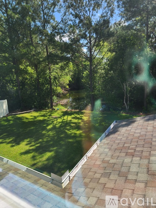 A backyard with a brick patio and a grassy area.