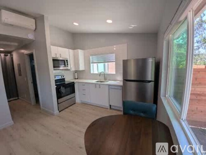 A kitchen with white cabinets and a wooden table.