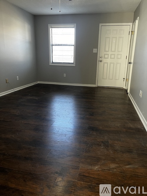 A room with wooden floors and a white door.