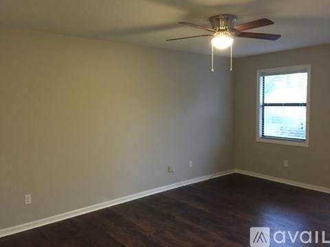 A room with a ceiling fan and a window.