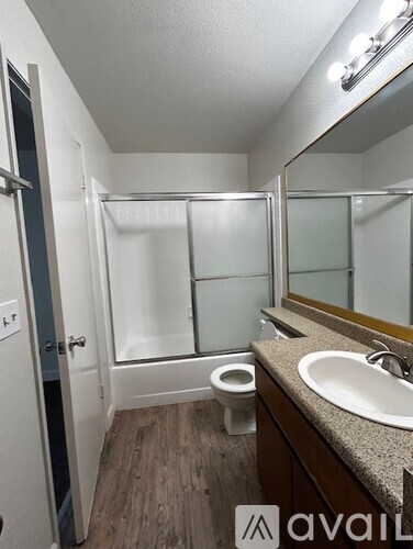 A bathroom with a toilet, sink, and mirror.