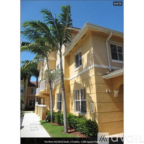 A yellow two-story apartment building with a balcony on the second floor.
