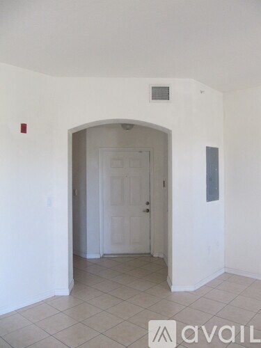 A hallway with a white door and a wall-mounted air vent.