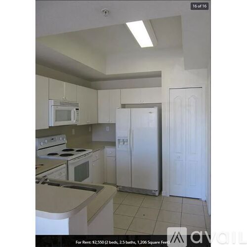 A kitchen with white appliances and cabinets.