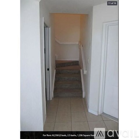 A hallway with stairs leading to a bedroom.