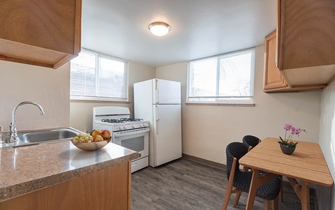A kitchen with a sink, stove, and refrigerator.