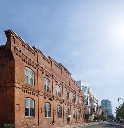 A row of red brick buildings line a street.