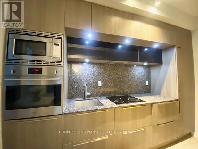 A modern kitchen with a stainless steel oven and microwave.