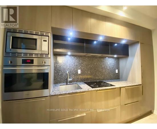 A modern kitchen with a stainless steel oven and microwave.