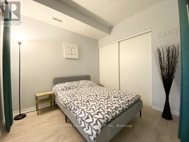 A bedroom with a bed, nightstand, and lamp.