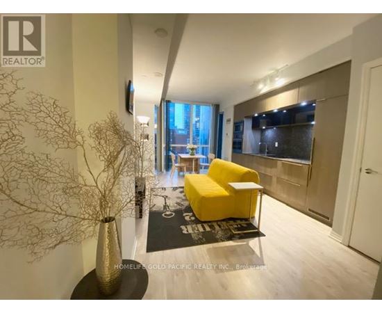 A modern living room with a yellow chair and a large window.