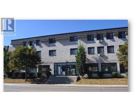 A building with a stone facade and a glass entrance.