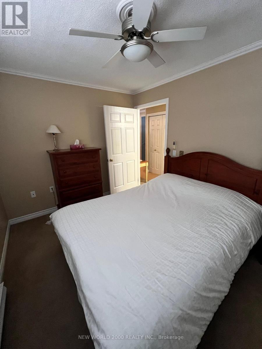 A bedroom with a large bed and a ceiling fan.