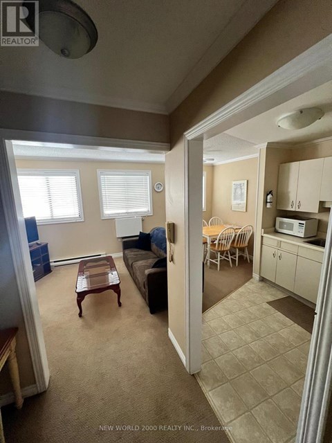 A living room with a couch, a coffee table, and a dining area with a table and chairs.
