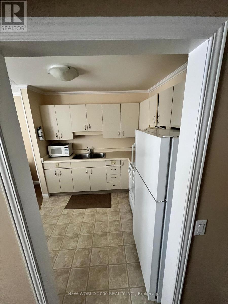 A kitchen with white appliances and cabinets.