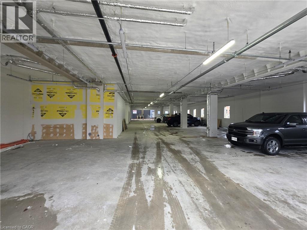 A large, empty garage with a car parked on the right side.