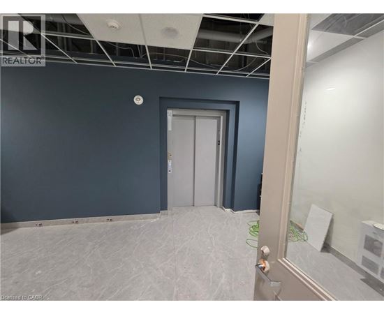 A room with a door and a wall with a hole in it.