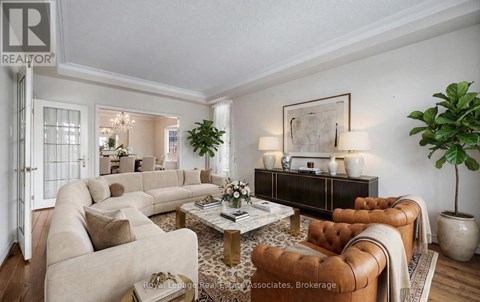 A living room with a grey couch and wooden floors.