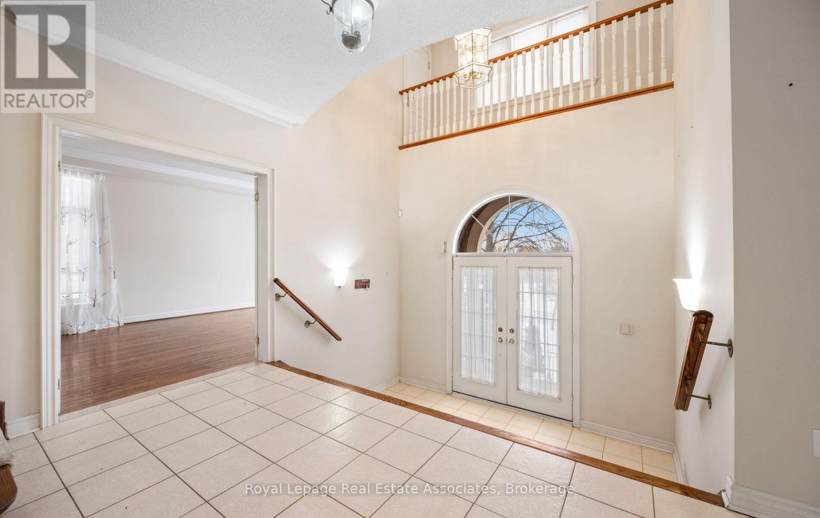 A spacious room with a staircase leading to the second floor.