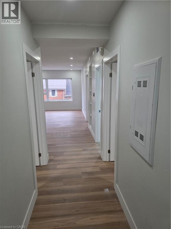 A long hallway with wood floors and white walls.