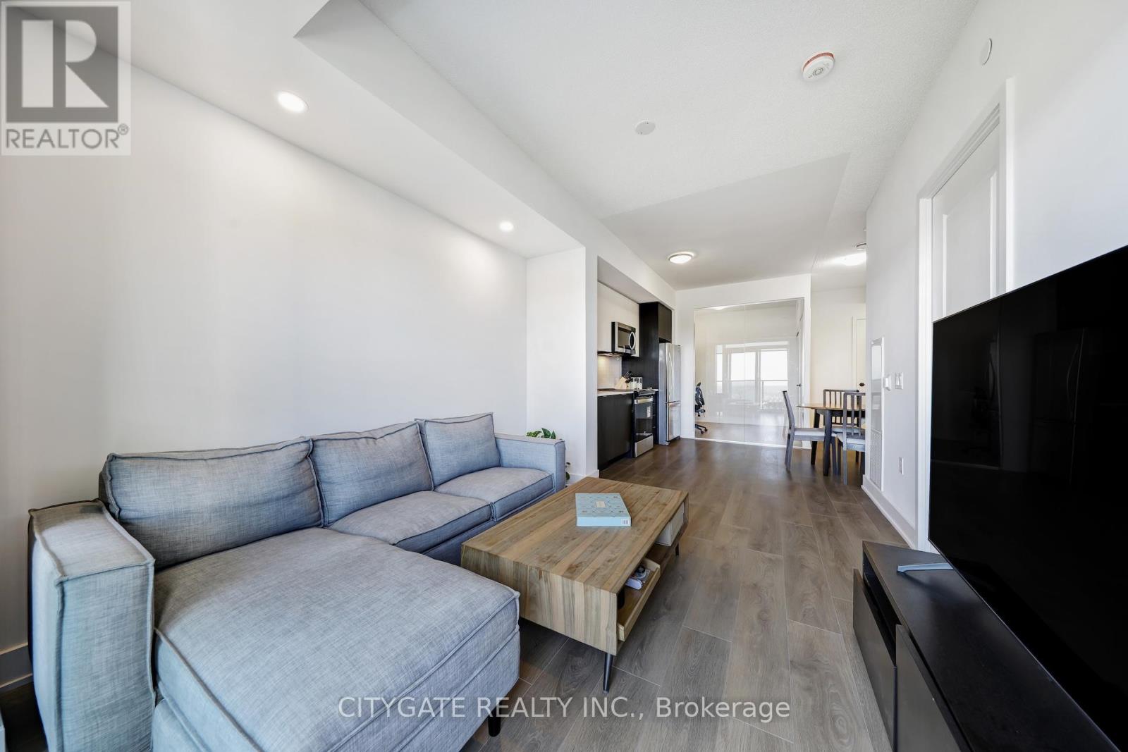 A living room with a grey couch and a wooden coffee table.