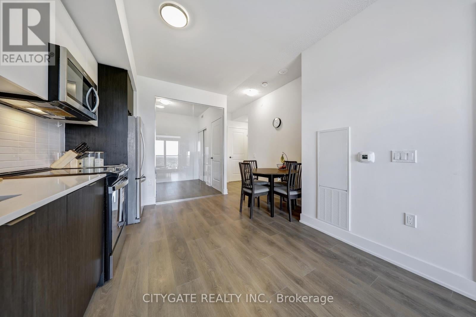 A kitchen with dark wood cabinets and a white countertop.