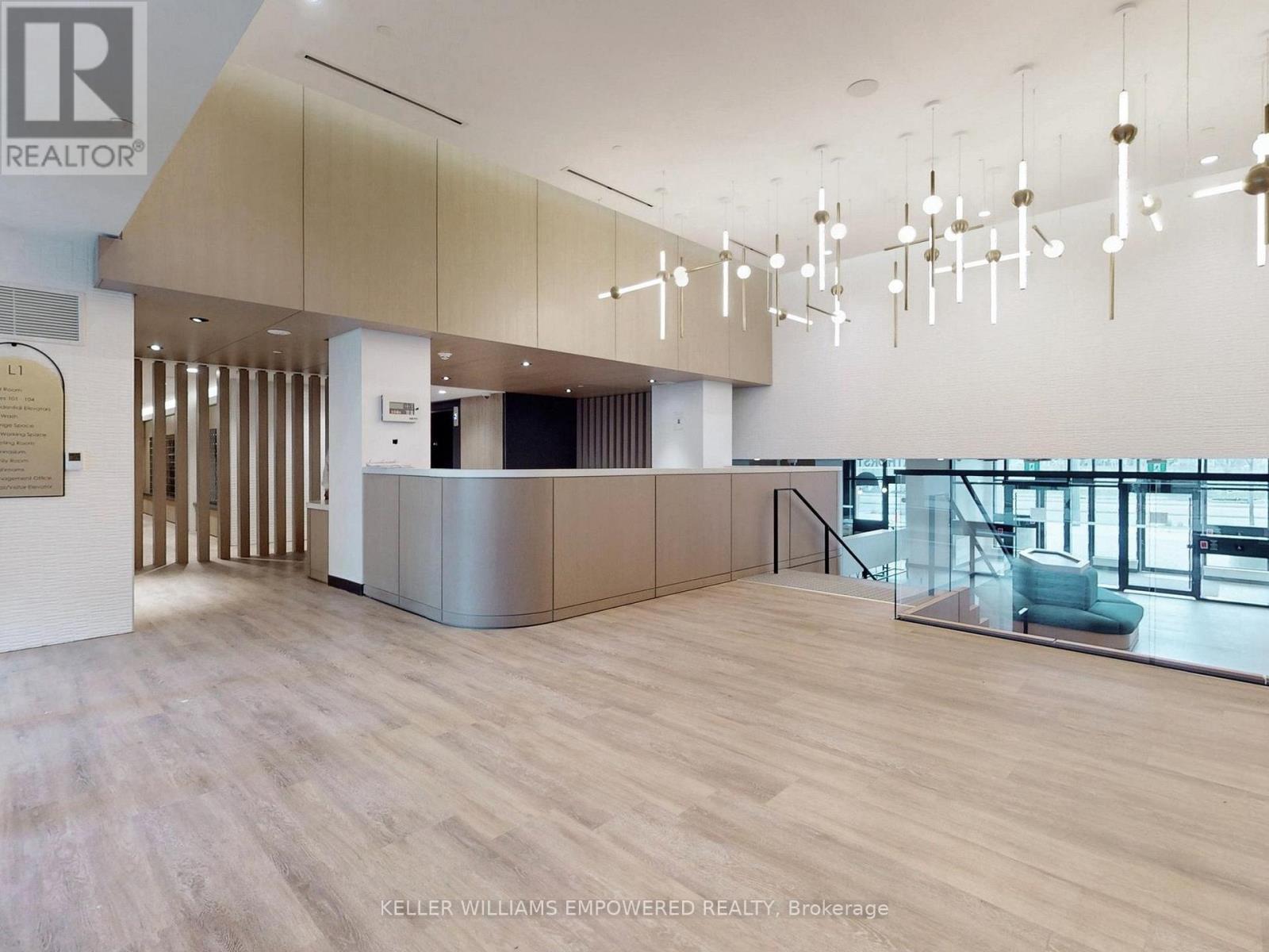 A spacious office lobby with wood floors and a reception desk.