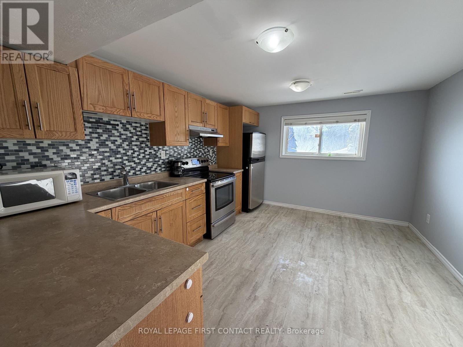 A kitchen with wooden cabinets and a tiled backsplash.