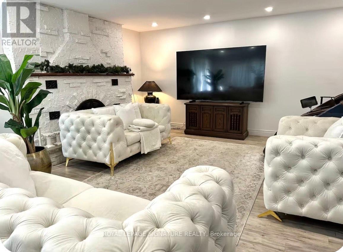 A living room with white furniture and a fireplace.
