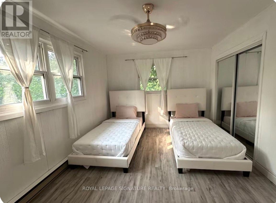 A bedroom with two beds and a chandelier.