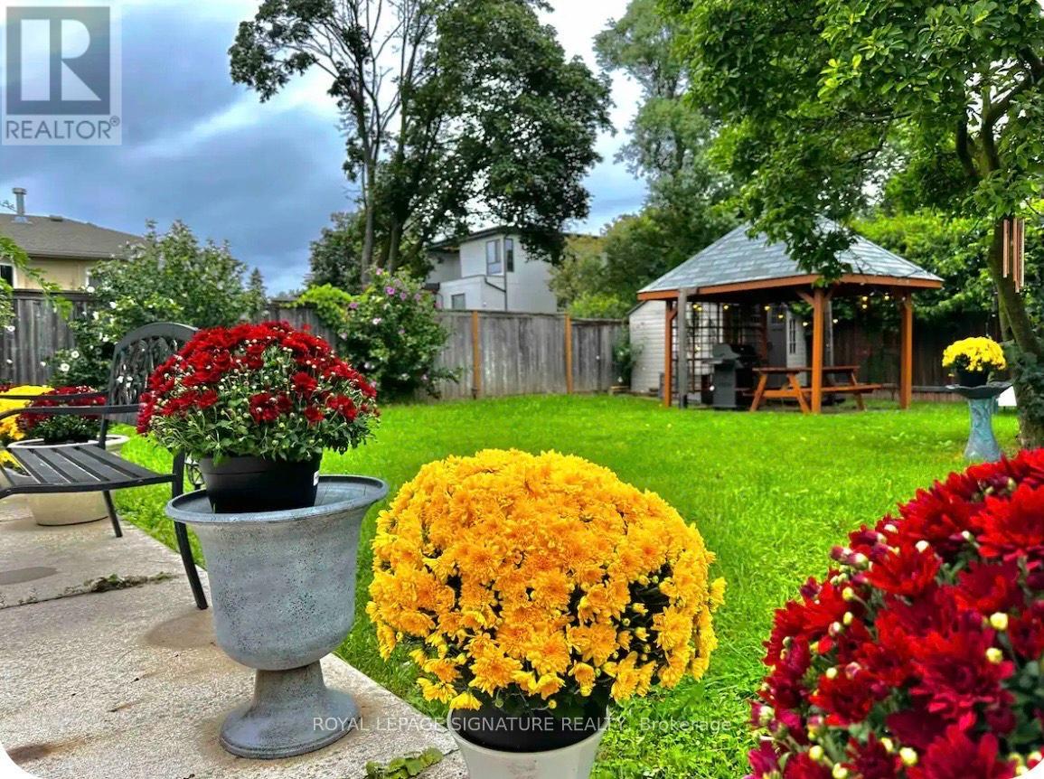A garden with a gazebo and flower pots.