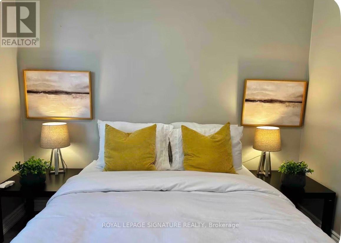 A bedroom with a white bed and two yellow pillows.