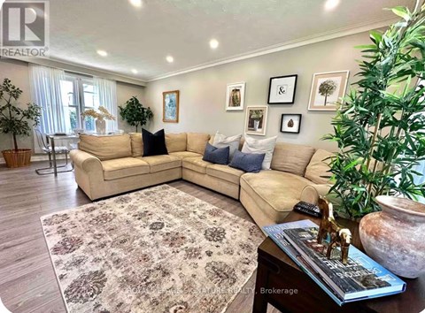 A living room with a beige sofa and a rug.