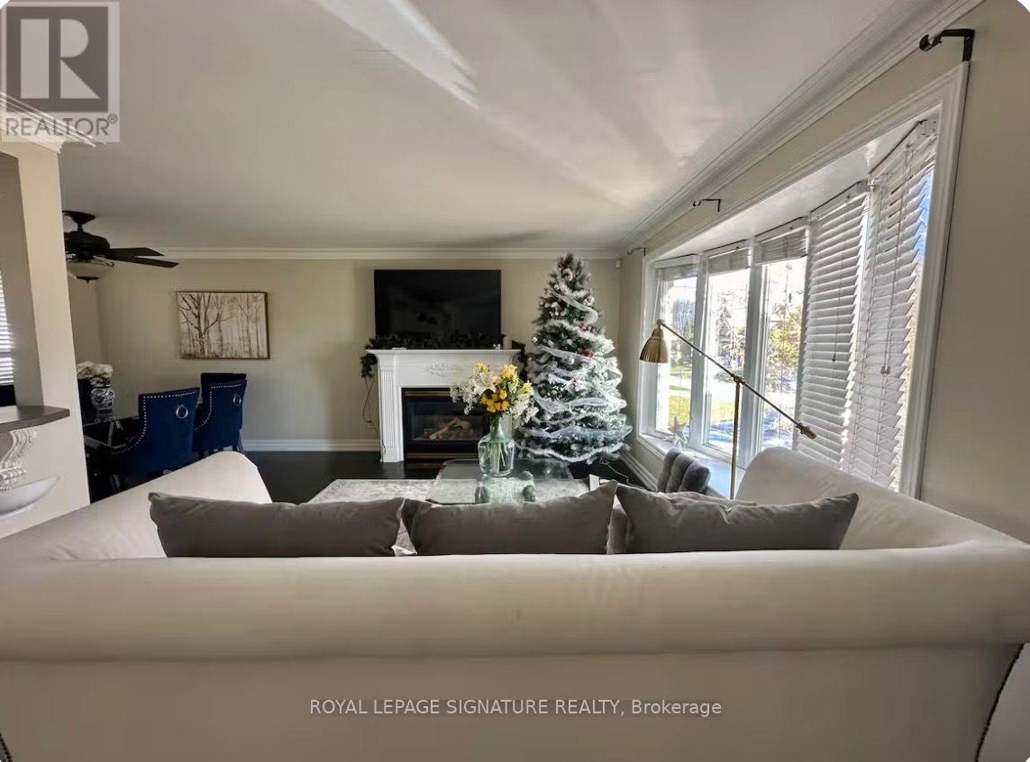 A living room with a Christmas tree and a fireplace.