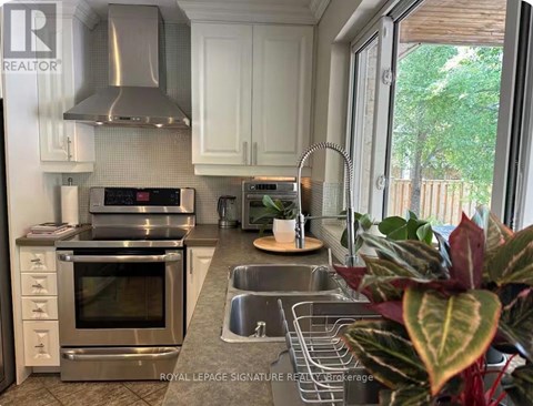 A kitchen with a stainless steel oven and sink.