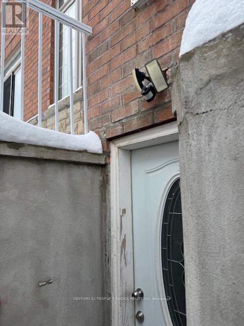A white door with a window above it and a brick wall behind it.
