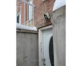 A white door with a window above it and a brick wall behind it.