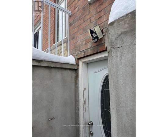 A white door with a window above it and a brick wall behind it.