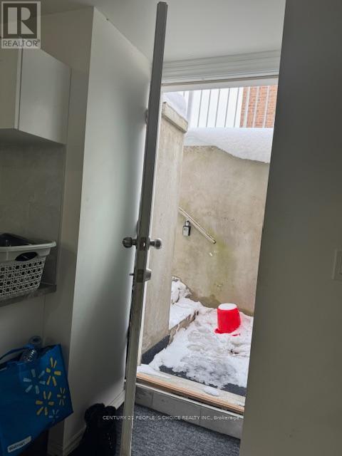 A view into a hallway with a door open to a snowy courtyard.