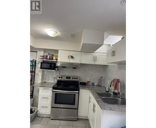 A kitchen with white cabinets and a stove top oven.