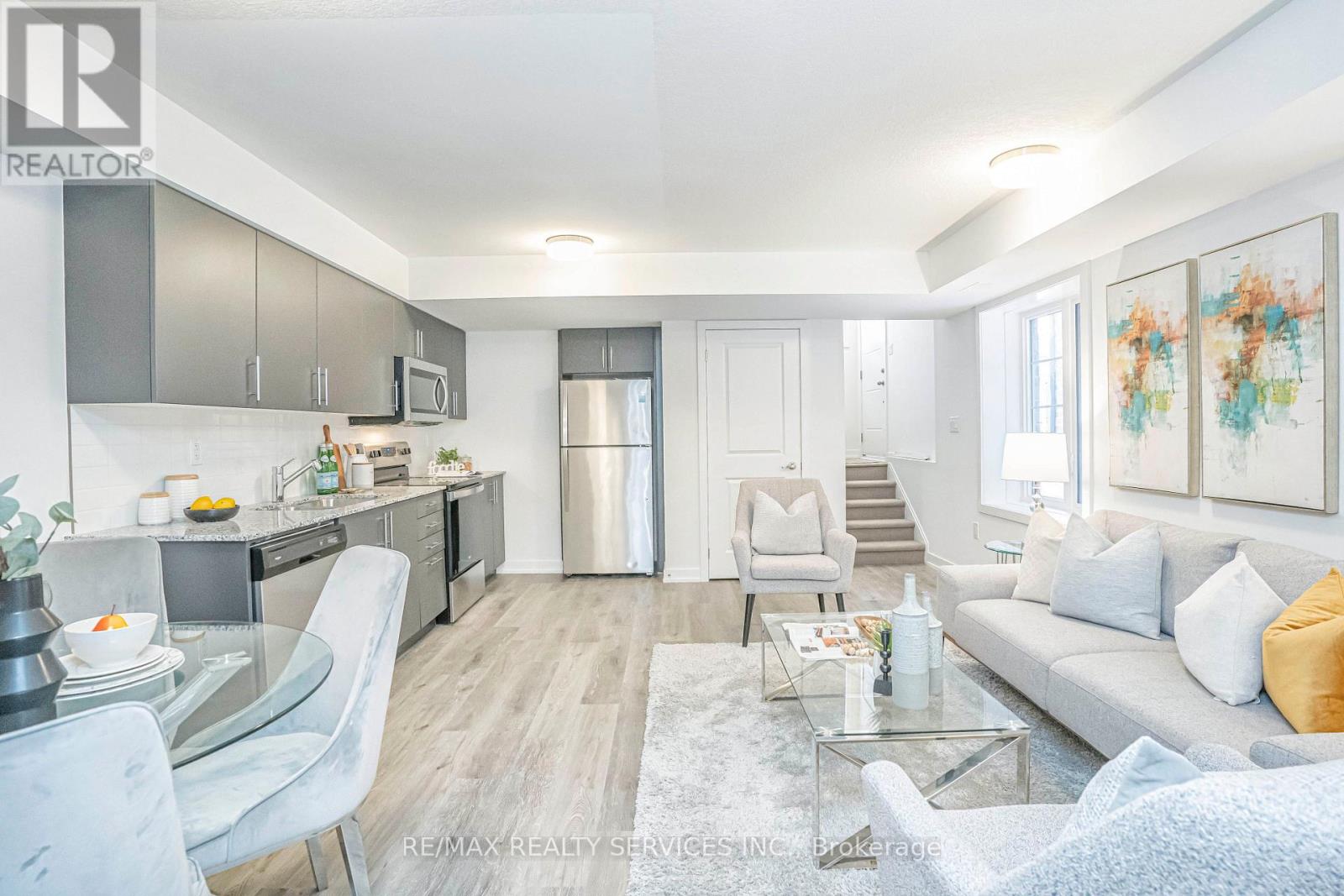 A modern open plan living and kitchen area with a dining table and chairs.