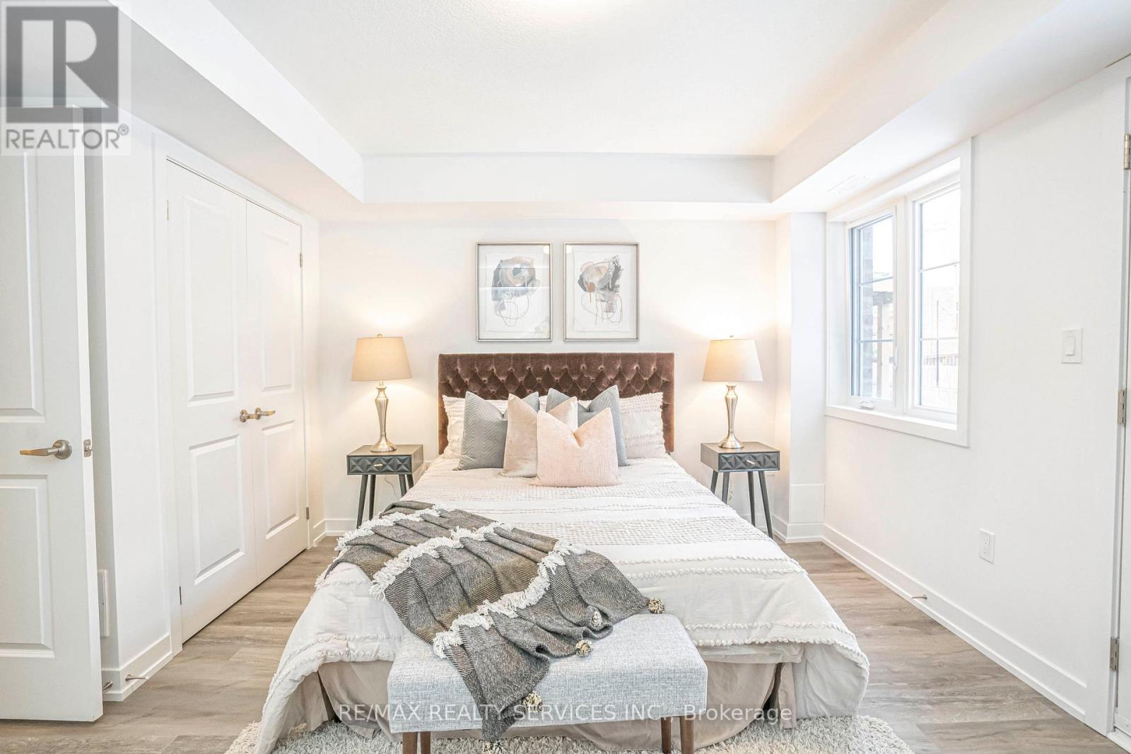 A bedroom with a large bed and a painting above it.