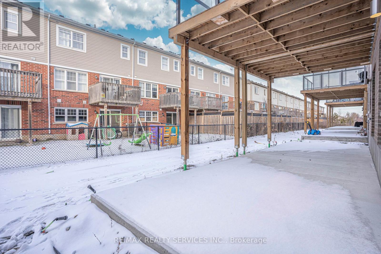 A snow-covered playground area with a wooden structure and a slide.