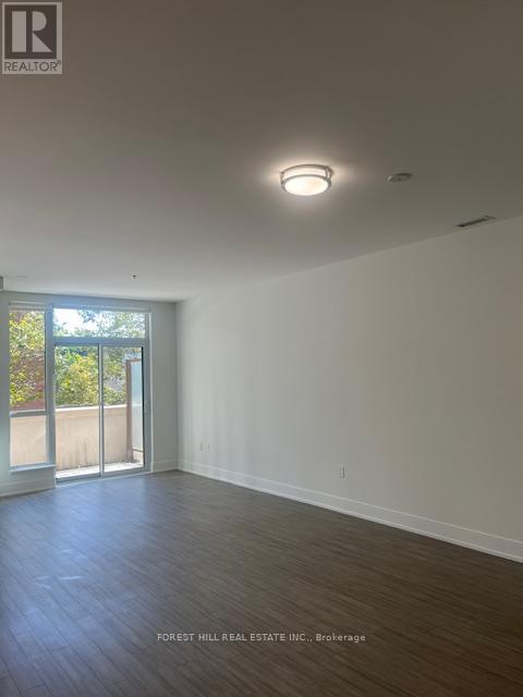 A spacious room with a sliding glass door leading to a balcony.