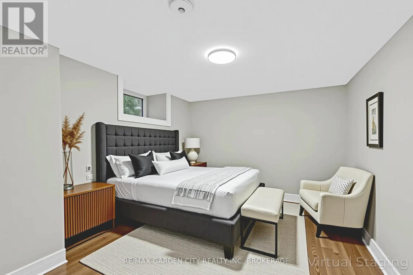 A bedroom with a large bed and a chair.